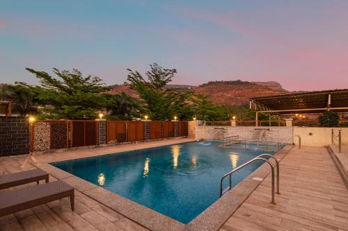 une grande piscine avec une terrasse en bois dans l'établissement Hillside Resort Lonavala - Pawna - Mountain View, à Lonavala