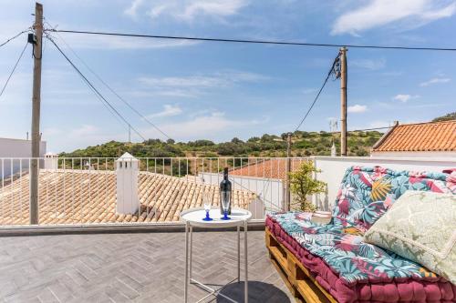 a patio with a couch and a table on a balcony at Casa Hortas in Vila do Bispo