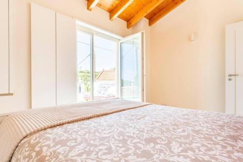 a bedroom with a bed and a large window at Casa Hortas in Vila do Bispo