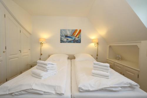 duas camas num quarto com toalhas brancas em Haus Freia - für den perfekten Familienurlaub em Westerland