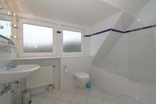 uma casa de banho com um lavatório, um WC e um chuveiro em Haus Freia - für den perfekten Familienurlaub em Westerland
