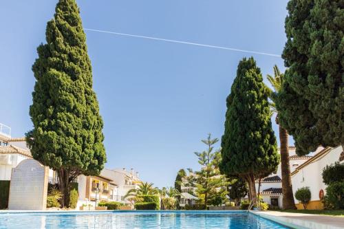 una piscina rodeada de árboles y edificios en Apartamento Puebla Lucia Fuengirola en Fuengirola