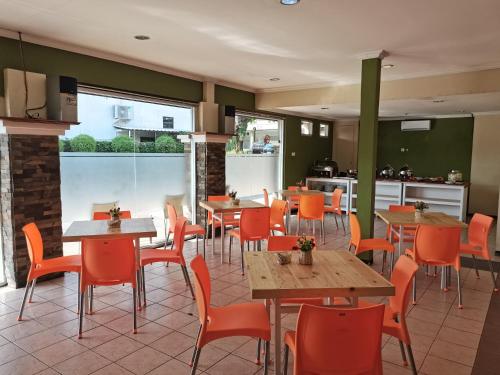 een restaurant met tafels en stoelen en een keuken bij Hotel Catur Putra in Magelang