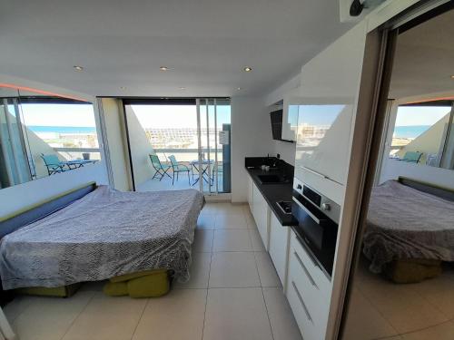 deux lits dans une chambre avec balcon dans l'établissement Studio Village Naturiste O Plaisir, au Cap d'Agde