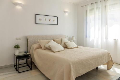 Habitación blanca con cama y ventana en Apartamento Puebla Lucia Fuengirola en Fuengirola