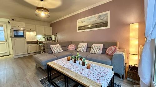 un salon avec un canapé et une table dans l'établissement La Villa Myla, au Crotoy
