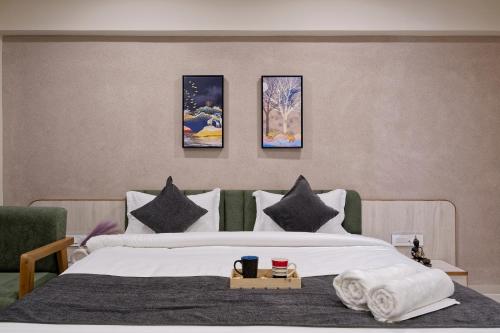 a bedroom with a bed with four paintings on the wall at Exora Inn in Ahmedabad