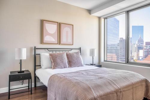 a bedroom with a bed and a large window at Theatre District 2br w wd gym nr theaters BOS-251A in Boston