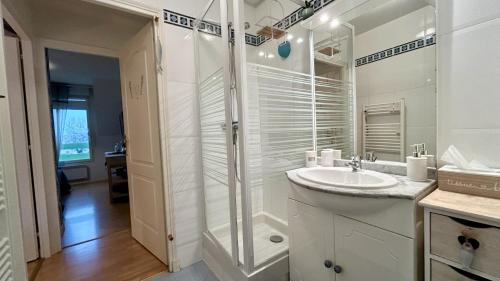 une salle de bain blanche avec un lavabo et une douche dans l'établissement La Villa Myla, au Crotoy
