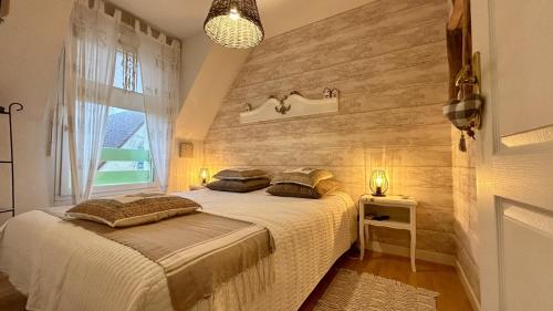 une chambre avec un lit et un mur en bois dans l'établissement La Villa Myla, au Crotoy