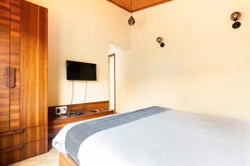 a bedroom with a bed and a flat screen tv at Hillside Resort Lonavala - Pawna - Mountain View in Lonavala