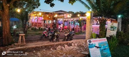 two motorcycles parked in front of a house at night at Achita Cottages in Senaru