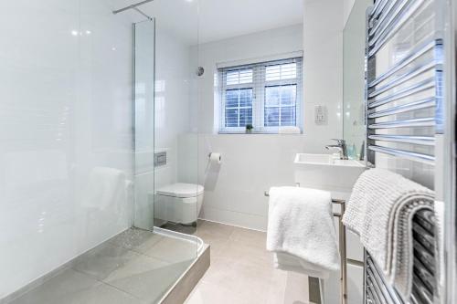 a white bathroom with a sink and a toilet at The Faculty by Celador Apartments in Reading