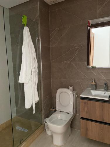 a bathroom with a toilet and a shower and a sink at Beaulieu du Park commode et paisible in Mohammedia