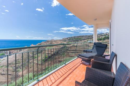 a balcony with chairs and a view of the ocean at Sunspot Reis Magos with sea view in Caniço