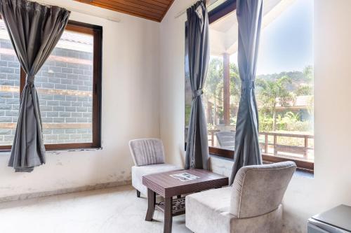 a room with two chairs and a table and a window at Hillside Resort Lonavala - Pawna - Mountain View in Lonavala