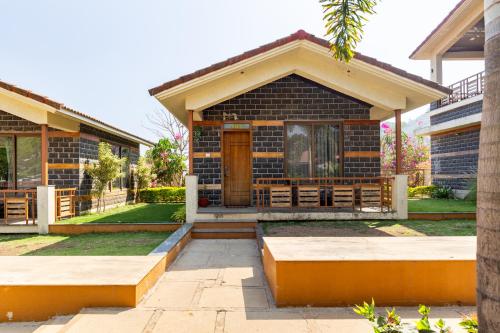 a house with a front porch with a wooden door at Hillside Resort Lonavala - Pawna - Mountain View in Lonavala