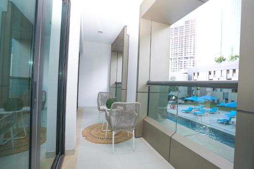 a balcony with a chair and a swimming pool at Business Bay 1BR Gem Luxe Living in Dubai