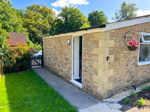 una casa in pietra con una porta e un cortile di The Annexe a Bruton