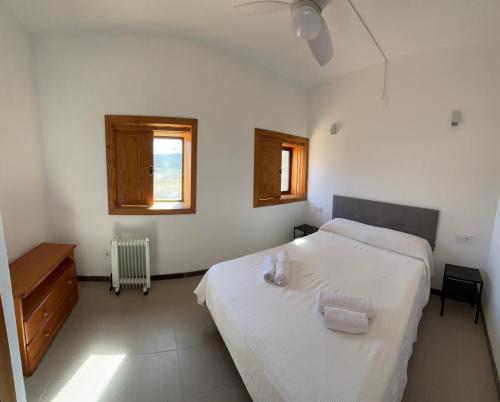 Calles的住宿－Chalet con piscina privada en Calles，一间白色卧室,配有两张床和窗户