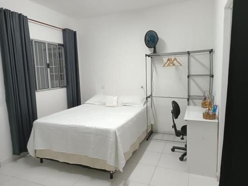 a bedroom with a bed and a desk and a chair at Inovally in Guarulhos