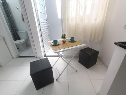 a small table and two stools in a room at Inovally in Guarulhos