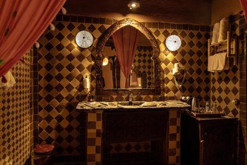 a bathroom with a sink and a mirror at Kasbah Hotel Xaluca Arfoud in Erfoud