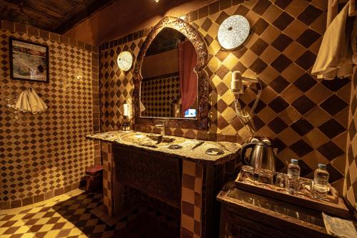 a bathroom with a sink and a mirror at Kasbah Hotel Xaluca Arfoud in Erfoud