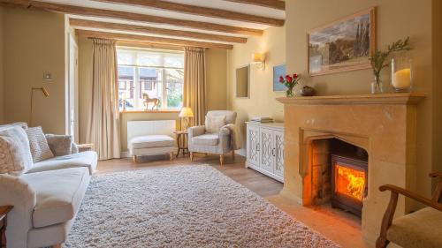 a living room with a fireplace and a couch at Wild Pear Cottage in Wolford