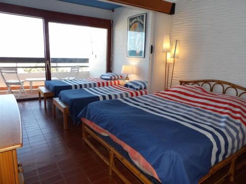 une chambre d'hôtel avec deux lits et un balcon dans l'établissement Superbe appart face a la mer a St Cyprien, à Saint-Cyprien