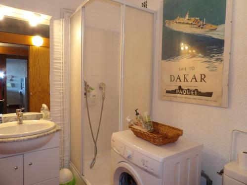 une salle de bain avec douche et machine à laver dans l'établissement Superbe appart face a la mer a St Cyprien, à Saint-Cyprien
