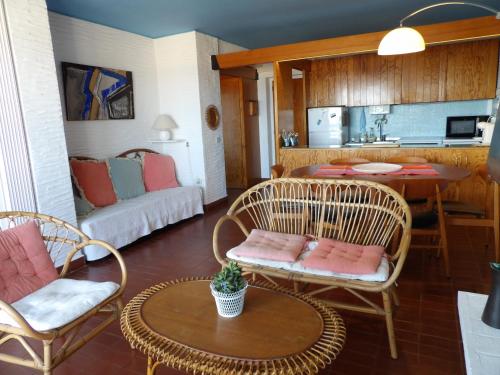 un salon avec des chaises et une table et une cuisine dans l'établissement Superbe appart face a la mer a St Cyprien, à Saint-Cyprien