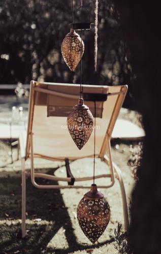 a chair with four pots hanging from it at De Rafael Cabañas de Madera in Venturada