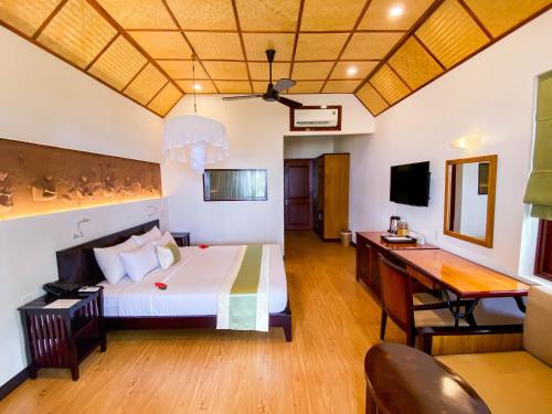 Pokój hotelowy z łóżkiem i biurkiem w obiekcie Bamboo Village Beach Resort & Spa w mieście Mui Ne