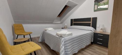 a small bedroom with a bed and a chair at APARTAMENTO Temple I in Ponferrada