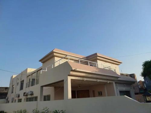 ein großes weißes Haus mit einem Zaun davor in der Unterkunft 5 Bedrooms furnished separate upper portion house in DHA Phase 4, Lahore in Lahore