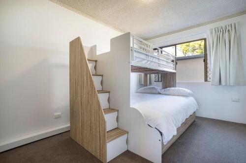 a bedroom with a bunk bed and a staircase at River Front Escape, Walk to Ocean St & Shops in Maroochydore