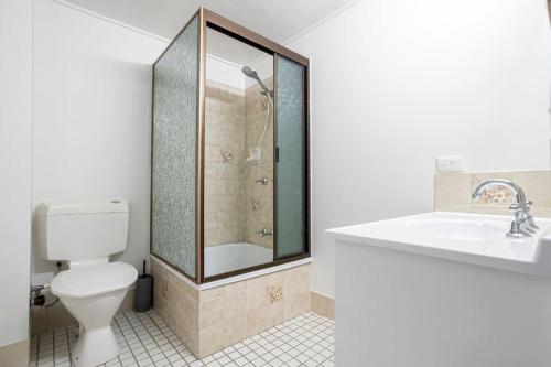 a bathroom with a shower and a toilet and a sink at River Front Escape, Walk to Ocean St & Shops in Maroochydore