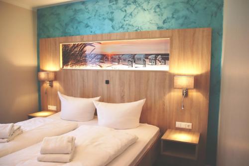バーベにあるR&R Villen Baabeのベッドが2つあり、壁に絵が飾られた寝室