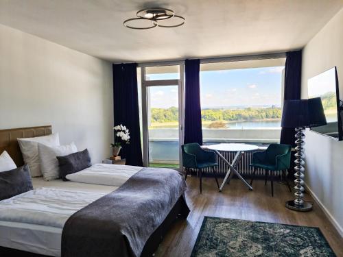 a hotel room with two beds and a table with a view at Rheinblick Apartments in Cologne
