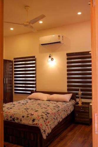 a bedroom with a bed and a ceiling fan at RIVA Marari Beach Homestay in Mararikulam