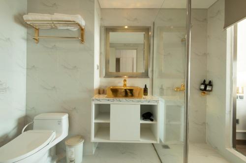La salle de bains est pourvue d'un lavabo, de toilettes et d'une douche. dans l'établissement GOLDEN APARTMENT With SEA VIEW, à Đà Nẵng