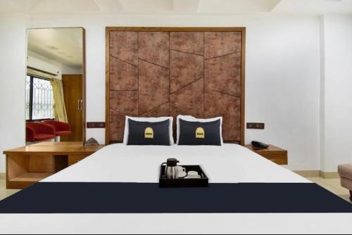 una camera da letto con un grande letto bianco con cuscini blu di Hotel Palace a Chandrapur