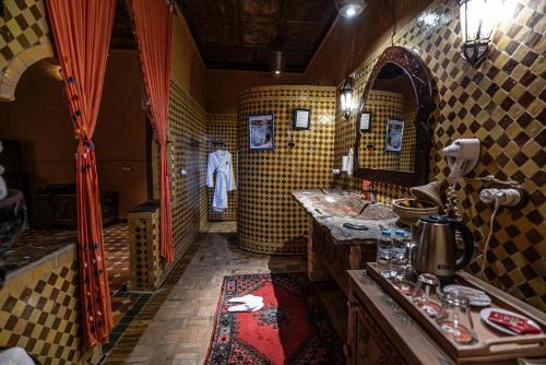 uma casa de banho com um lavatório e um espelho em Kasbah Hotel Xaluca Arfoud em Erfoud
