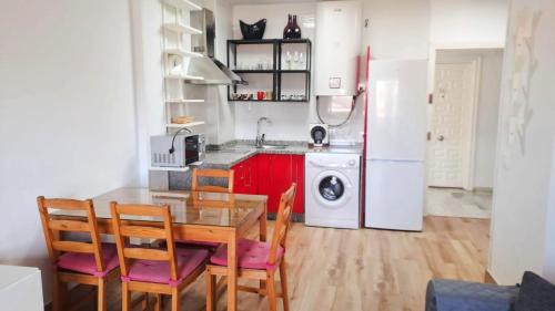 een keuken met een tafel, stoelen en een koelkast bij BENALBEACH RESORT NEW APARTMENT - Benalmádena Málaga in Benalmádena
