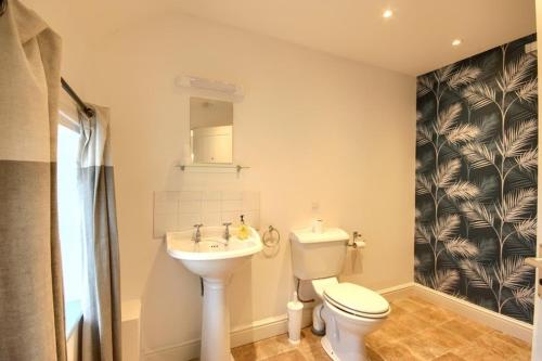 een badkamer met een toilet en een wastafel bij Smugglers Luxury Accommodation in Sheringham