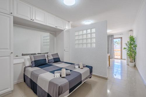 a bedroom with a large bed in a white room at Complejo Tenerife Royal Garden in Playa de las Americas