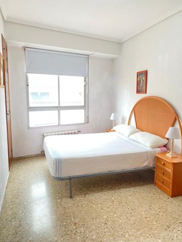 a bedroom with a large bed and a window at Casa del port in Grao de Castellón