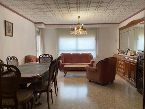 a dining room with a table and chairs and a couch at Casa del port in Grao de Castellón