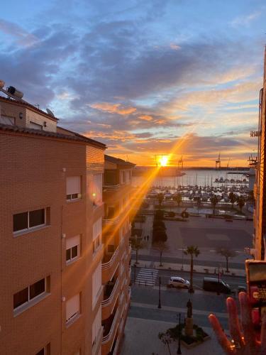 una puesta de sol sobre un estacionamiento con un edificio en Casa del port, en Grao de Castellón